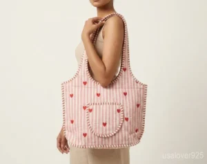 Pink Red Quilted Cotton Tote Bag with comfortable over-the-shoulder handles held against a natural background.