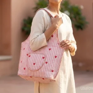 Pink Red Quilted Cotton Tote Bag with comfortable over-the-shoulder handles held against a natural background.