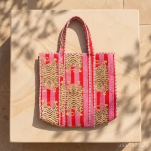 Woman walking at a beach resort carrying an extra large Pink Tiger Print Reversible Quilted Tote packed with travel essentials.