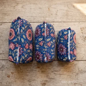 A three-piece nesting set of Purple Floral Quilted Cotton Toiletry Bags neatly arranged on a clean marble bathroom vanity counter showing the large, medium, and small size profiles.