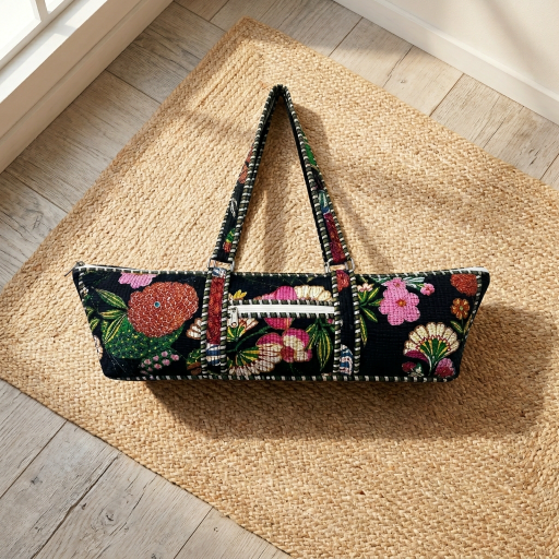 Close-up of the handcrafted black floral print detailing, dense quilted stitching texture lines, robust handle strap attachments, and exterior front zipper pocket on an Indian cotton Pilates carrier bag.