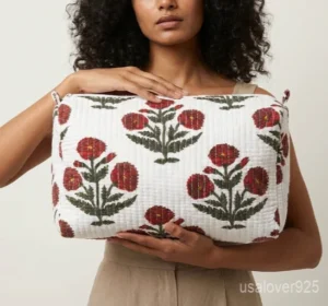 Close-up of the handcrafted floral block print detailing, dense quilted stitching lines, waterproof internal lining layer, and clean zipper slider on an Indian cotton cosmetic pouch bag.