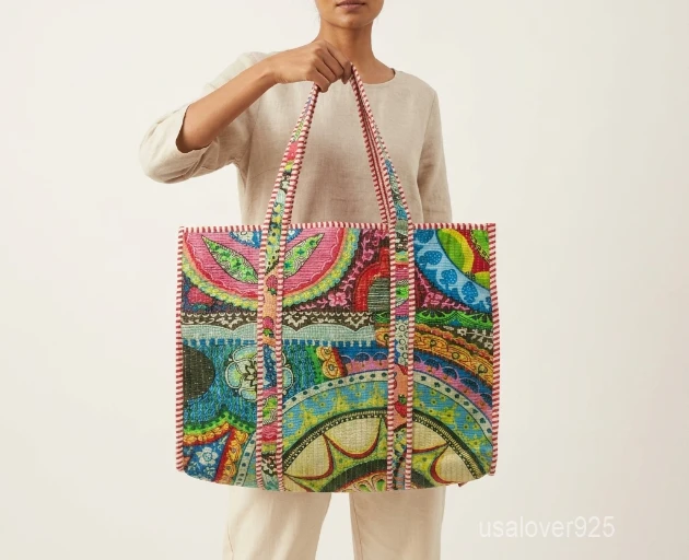 Close-up of the traditional block print detailing, dense parallel line quilted stitching rows, and comfortable 13-inch shoulder handles on an Indian cotton tote bag.