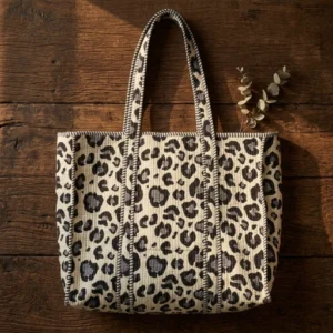 A shopper carrying the Exotic Cat Quilted Cotton Tote Bag by the wide straps, showcasing its generous packing capacity and vibrant bohemian accessory style at an outdoor market.