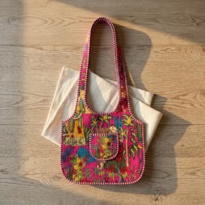Close-up of the handcrafted pink botanical print detailing, dense quilted stitching texture lines, robust handle strap attachments, secure zipper slider, and neat inner pocket slot on an Indian cotton carryall tote.