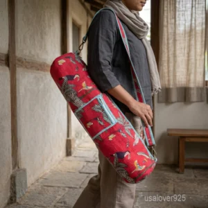 Close-up of the integrated external pocket, full-length zipper closure, and premium quilted stitching on a red cotton yoga bag.