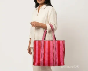 Close-up of the red botanical block print detailing, dense parallel line quilted stitching rows, square layout profile, and comfortable 13-inch handles on an Indian cotton tote bag.