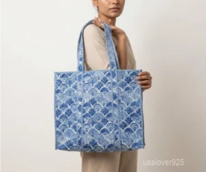 Close-up of the blue floral block print detailing, dense parallel line quilted stitching rows, supportive 6-inch bottom gusset base, and reversible double-sided pattern layout on an Indian cotton tote bag.