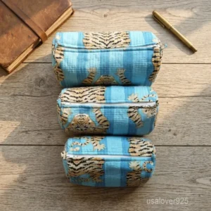 A three-piece nesting set of Cotton Floral Print Toiletry Bags neatly arranged on a clean marble bathroom vanity counter showing the large, medium, and small size profiles.