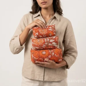 A three-piece nesting set of Cotton Floral Print Toiletry Bags neatly arranged on a clean marble bathroom vanity counter showing the large, medium, and small size profiles.