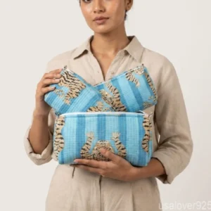 Close-up of the handcrafted botanical print detailing, dense vertical quilted stitching rows, waterproof internal plastic lining, and built-in inside pockets on an Indian cotton cosmetic caddy pouch.