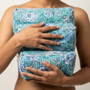 Close-up of the handcrafted traditional print detailing, dense quilted stitching rows, waterproof internal plastic inner lining, elegant beads, and handcrafted tassel on an Indian cotton cosmetic pouch caddy.