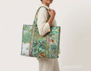 Close-up of the exotic jungle print detailing, dense parallel line quilted stitching rows, and comfortable 12-inch handles on an Indian cotton shopper bag.