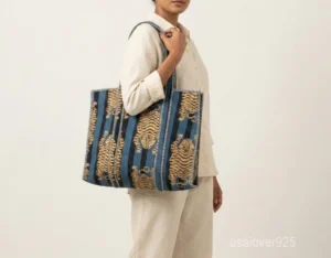 Close-up of the exotic jungle print detailing, dense parallel line quilted stitching rows, and comfortable 13-inch shoulder handles on an Indian cotton shopper bag.