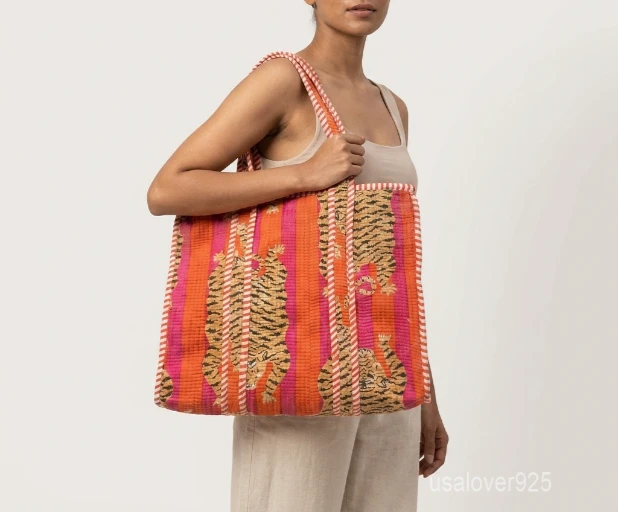 A person carrying a Tiger Print Quilted Cotton Tote Bag comfortably over their shoulder during a casual city commute.