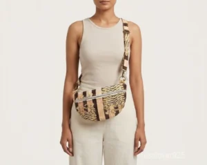 A person holding a compact Tiger Print Soft Quilted Cotton Mini Bag by its top handle during an evening party outing.