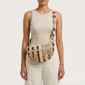 A person holding a compact Tiger Print Soft Quilted Cotton Mini Bag by its top handle during an evening party outing.