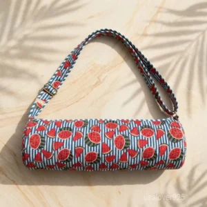 Close-up of the handcrafted watermelon print detailing, contrasting striped accents, dense quilted stitching texture lines, robust handle strap attachments, and clean zip track on an Indian cotton Pilates carrier bag.