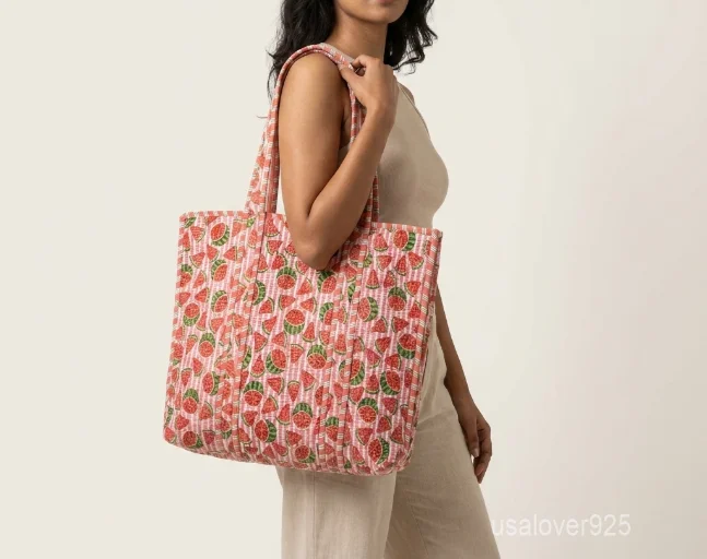 Close-up of the traditional hand-running Kantha embroidery stitches, playful watermelon motif detailing, soft cotton fabric texture, and handles on an Indian upcycled shopper bag.