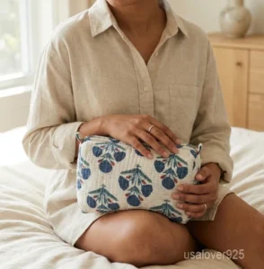 A three-piece nesting set of White Floral Quilted Cotton Toiletry Bags neatly arranged on a clean vanity counter showing the large, medium, and small size profiles.