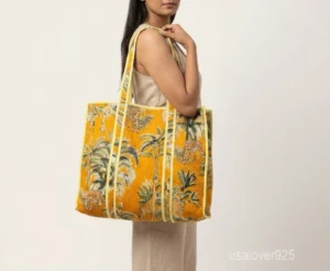Close-up of the exotic jungle print detailing, dense parallel line quilted stitching rows, and comfortable 13-inch handles on an Indian cotton shopper bag.