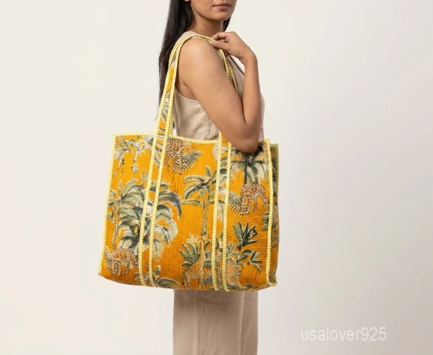 Close-up of the exotic jungle print detailing, dense parallel line quilted stitching rows, and comfortable 13-inch handles on an Indian cotton shopper bag.
