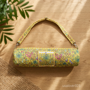 Close-up of the handcrafted yellow block print detailing, dense quilted stitching tracks, heavy-duty metal clasps, and adjustable crossbody strap on an Indian cotton fitness mat bag.