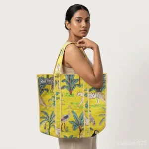 Yellow Jungle Print Quilted Cotton Tote Bag with comfortable over-the-shoulder handles held against a natural background.