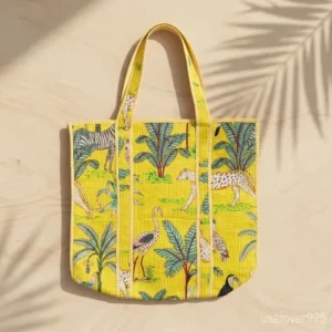 Close-up of rich yellow jungle botanical pattern and high-quality quilted stitching on an extra large cotton tote bag.