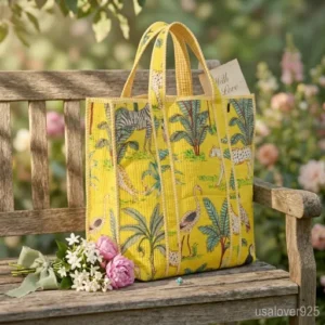 Yellow Jungle Print Quilted Cotton Tote Bag with comfortable over-the-shoulder handles held against a natural background.