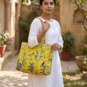 A shopper carrying the Yellow Jungle Print Quilted Cotton Tote Bag by the wide straps, showcasing its generous extra-large packing capacity and bright bohemian accessory style at an outdoor market.