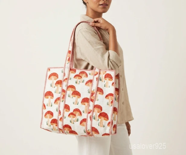 Close-up of the yellow mushroom print, dense Italian thread diamond quilted stitching, and comfortable 12-inch handle drop straps on an Indian cotton shopper bag.