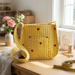 Woman walking through an outdoor market wearing a Yellow Pink Heart Quilted Cotton Crossbody Bag as a comfortable shoulder pouch.