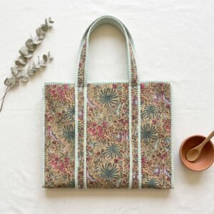 Close-up of the handcrafted beige botanical print detailing, dense quilted stitching texture lines, robust handle strap attachments, and clean inner layout on an Indian cotton travel purse.