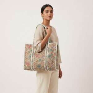 A shopper carrying the Beige Floral Quilted Tote Bag by the wide straps, showcasing its generous packing capacity and elegant large shoulder handbag style at an outdoor farmers market.