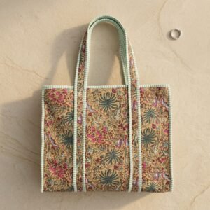 Close-up of the handcrafted beige botanical print detailing, dense quilted stitching texture lines, robust handle strap attachments, and clean inner layout on an Indian cotton travel purse.