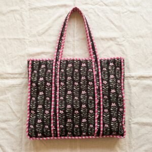 Close-up of the handcrafted black floral print detailing, dense quilted stitching texture lines, robust handle strap attachments, and clean inner layout on an Indian cotton carryall tote.
