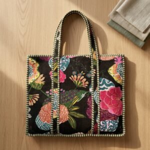 Close-up of the handcrafted black floral print detailing, traditional chintz pattern layouts, dense quilted stitching texture lines, robust handle strap attachments, and clean inner layout on an Indian cotton travel purse.