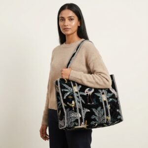 A shopper carrying the Black Safari Quilted Tote Bag by the wide straps, showcasing its generous packing capacity and elegant exotic cat shoulder handbag style at an outdoor market.