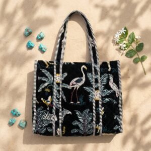 Close-up of the handcrafted black jungle print detailing, dense quilted stitching texture lines, robust handle strap attachments, and clean inner layout on an Indian cotton travel purse.