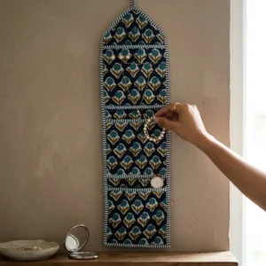 An interior room setup showing the Blue Indigo Quilted Wall Hanging Organizer near a wooden office desk, showcasing its space-saving capacity and elegant patterned office home pocketbook style.