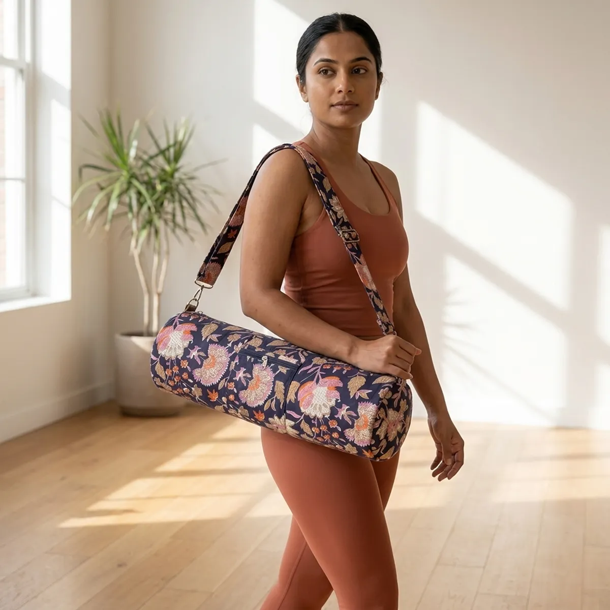 Close-up of the handcrafted multicolored floral detailing, dense quilted tracking lines, robust zipper attachment, and metal adjusting slider buckle on the fitness tote.