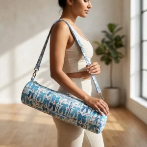 An outdoor studio scene featuring the Blue Ribbon Quilted Cotton Yoga Mat Bag draped across a person's shoulder, highlighting its lightweight hands-free carrying convenience and bohemian style.