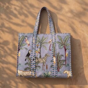 ## Carry Elegant Artisan Charm with the Blue Safari Quilted Tote Bag
Step up your grocery shopping trips, sunny beach days, and casual office commutes with our beautiful Blue Safari Quilted Tote Bag. This is not a basic, mass-produced synthetic shopper or a rigid nylon sack; it is a meticulously handcrafted masterpiece created by traditional artisan communities in Jaipur, Rajasthan. By merging traditional Indian handprinted textile heritage with a functional, heavy-duty padded shoulder carryall frame, this multi-purpose daily travel purse serves as a beautiful practical lifestyle piece.The classic rich indigo backdrop coupled with a bold hand block printed jungle print layout and artisan animal motif details infuses your summer resort wear accessory collection with an effortless, free-spirited bohemian charm. It is perfect for frequent jetsetters, busy parents, beachgoers, campus students, and conscious individuals who value slow fashion, vivid wildlife accents, exotic cat aesthetics, and ethical handmade goods that elevate daily storage routines.### Artisan Quality: Authentic Handprinted Heritage from Jaipur
Every line of our Blue Safari Quilted Tote Bag shopper represents the deep cultural heritage of rural Indian makers. Our team of independent regional craftsmen carefully selects premium panels of pure sustainable cotton fabric. The material undergoes a detailed processing manual block print design application to transfer the beautiful wild cat elements and traditional wilderness layouts onto the cotton layers using hand-carved wooden blocks and natural plant-derived organic pigments. Once the canvas panels are printed, they are layered with premium soft cotton filling insulation batting and run through extensive tracks of dense hand-machined quilted stitching lines.This manual layered tailoring technique provides a beautifully unique textured exterior that delivers a soft, cushioned touch while significantly reinforcing the overall textile frame against external friction. Heavily reinforced cross-stitching is executed at all critical pressure and weight-bearing junction spots along the padded shoulder handles to ensure structural longevity under daily weight loads. Because each cotton market purse is individually styled by real human hands, minor shifts in print layout tracking, stitching lines, or color depth natural variations are completely typical signatures of manual textile tailoring that support traditional heritage communities.### Spacious Square Silhouette, Long Shoulder Straps, and Padded Protection
Engineered for the fast-paced modern lifestyle, active commuters, fitness lovers, and organization enthusiasts, this functional everyday tote bag handles your clothing sets, notebooks, books, and tech tablets securely without adding unnecessary structural bulk or weight to your shoulders.Cushioned Textile Protection: The dense, multi-layered quilted cotton exterior build provides a natural, shock-absorbing protective barrier around your personal items, shielding sensitive e-readers, computing devices, or fragile sunglasses from daily transit impact bumps.Comfortable Double Shoulder Straps: Outfitted with wide, heavy-duty quilted handles designed to sit perfectly on your shoulder or carry by hand, distributing load weight evenly for maximum all-day transit comfort.Spacious Square Workspace Layout: Features a massive 18 x 18 inches horizontal and vertical footprint workspace to allow clean, layered packing organization and unrestricted visibility when locating items on the fly.Lightweight & Foldable Structure: The naturally soft, pliable framework compresses flat seamlessly, making it highly travel-friendly to stow inside larger luggage trunks for vacation getaways.The highly flexible, breathable cotton frame remains naturally soft-structured and incredibly lightweight, allowing it to compress flat or roll up easily inside larger traveling suitcases for vacation getaways, road trips, or grocery runs.## Product Specifications & Technical Dimensions Layout
Total Front Length Clearance: 18 Inches — Spacious horizontal footprint that comfortably holds books, beach towels, and daily necessities.Total Vertical Height Profile: 18 Inches — Generous vertical clearance ensuring restriction-free packing storage.Material Composition: 100% Premium Sustainable Breathable Indian Cotton fabric with soft quilted layers.Aesthetic Configuration: Elegant Indigo Jungle Print Patterned Large Shoulder Handbag.Origin: Proudly Handcrafted by local artisans in Jaipur, Rajasthan, India.Important Custom Note: This listing includes the quilted carry tote bag only. Storage props, lifestyle electronics, clothing sets, or sunglasses shown in studio photos are used for visual presentation only and are not included with your purchase. Minor structural shifts or print natural variations are typical signatures of manual textile tailoring.### Multipurpose Utility for a Sophisticated Lifestyle Statement
This eye-catching tiger print travel purse transitions flawlessly between different lifestyle activities throughout your busy schedule. Use the layout seamlessly as a grocery shopping tote, farmers market shopper, beach vacation carryall, university book bag, casual office utility handbag, gym caddy, or premium wildlife travel carrier. The timeless regional artisan print details coordinate beautifully with your casual wardrobe, adding a splash of fresh energy to your look.It stands out as an exceptional, highly useful eco-friendly wellness gift choice for birthdays, holidays, graduation achievements, bridesmaid proposal packs, or a thoughtful handmade surprise pack for travel lovers, beachgoers, and friends who appreciate detailed block print patterns and functional artisan craftsmanship.### Simple Care Instructions for Lasting Longevity
To maintain the structural form, protect the organic cotton fibers, and preserve the rich pigments of your Blue Safari Quilted Tote Bag, this shoulder carryall is highly straightforward to maintain at home. We recommend a gentle hand wash separately in cold water using a mild, eco-safe detergent to protect the deep indigo tones and detailed jungle prints. Avoid using concentrated chlorine bleaching solutions, and do not use high-heat automated machine tumble dryers or aggressive spin cycles.Reshape the fabric structure gently while damp and hang to line air dry flat completely in a shaded outdoor area away from direct sunlight to preserve the organic cotton threads and shield the detailed print layouts from direct UV color fading, keeping your everyday boho shopper bag crisp, vivid, structural, and clean for years of continuous adventures.