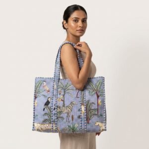 A shopper carrying the Blue Safari Quilted Tote Bag by the wide straps, showcasing its generous packing capacity and elegant exotic cat shoulder handbag style at an outdoor market.