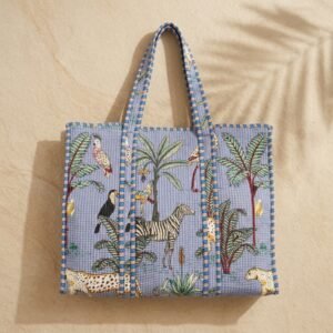 ## Carry Elegant Artisan Charm with the Blue Safari Quilted Tote Bag
Step up your grocery shopping trips, sunny beach days, and casual office commutes with our beautiful Blue Safari Quilted Tote Bag. This is not a basic, mass-produced synthetic shopper or a rigid nylon sack; it is a meticulously handcrafted masterpiece created by traditional artisan communities in Jaipur, Rajasthan. By merging traditional Indian handprinted textile heritage with a functional, heavy-duty padded shoulder carryall frame, this multi-purpose daily travel purse serves as a beautiful practical lifestyle piece.The classic rich indigo backdrop coupled with a bold hand block printed jungle print layout and artisan animal motif details infuses your summer resort wear accessory collection with an effortless, free-spirited bohemian charm. It is perfect for frequent jetsetters, busy parents, beachgoers, campus students, and conscious individuals who value slow fashion, vivid wildlife accents, exotic cat aesthetics, and ethical handmade goods that elevate daily storage routines.### Artisan Quality: Authentic Handprinted Heritage from Jaipur
Every line of our Blue Safari Quilted Tote Bag shopper represents the deep cultural heritage of rural Indian makers. Our team of independent regional craftsmen carefully selects premium panels of pure sustainable cotton fabric. The material undergoes a detailed processing manual block print design application to transfer the beautiful wild cat elements and traditional wilderness layouts onto the cotton layers using hand-carved wooden blocks and natural plant-derived organic pigments. Once the canvas panels are printed, they are layered with premium soft cotton filling insulation batting and run through extensive tracks of dense hand-machined quilted stitching lines.This manual layered tailoring technique provides a beautifully unique textured exterior that delivers a soft, cushioned touch while significantly reinforcing the overall textile frame against external friction. Heavily reinforced cross-stitching is executed at all critical pressure and weight-bearing junction spots along the padded shoulder handles to ensure structural longevity under daily weight loads. Because each cotton market purse is individually styled by real human hands, minor shifts in print layout tracking, stitching lines, or color depth natural variations are completely typical signatures of manual textile tailoring that support traditional heritage communities.### Spacious Square Silhouette, Long Shoulder Straps, and Padded Protection
Engineered for the fast-paced modern lifestyle, active commuters, fitness lovers, and organization enthusiasts, this functional everyday tote bag handles your clothing sets, notebooks, books, and tech tablets securely without adding unnecessary structural bulk or weight to your shoulders.Cushioned Textile Protection: The dense, multi-layered quilted cotton exterior build provides a natural, shock-absorbing protective barrier around your personal items, shielding sensitive e-readers, computing devices, or fragile sunglasses from daily transit impact bumps.Comfortable Double Shoulder Straps: Outfitted with wide, heavy-duty quilted handles designed to sit perfectly on your shoulder or carry by hand, distributing load weight evenly for maximum all-day transit comfort.Spacious Square Workspace Layout: Features a massive 18 x 18 inches horizontal and vertical footprint workspace to allow clean, layered packing organization and unrestricted visibility when locating items on the fly.Lightweight & Foldable Structure: The naturally soft, pliable framework compresses flat seamlessly, making it highly travel-friendly to stow inside larger luggage trunks for vacation getaways.The highly flexible, breathable cotton frame remains naturally soft-structured and incredibly lightweight, allowing it to compress flat or roll up easily inside larger traveling suitcases for vacation getaways, road trips, or grocery runs.## Product Specifications & Technical Dimensions Layout
Total Front Length Clearance: 18 Inches — Spacious horizontal footprint that comfortably holds books, beach towels, and daily necessities.Total Vertical Height Profile: 18 Inches — Generous vertical clearance ensuring restriction-free packing storage.Material Composition: 100% Premium Sustainable Breathable Indian Cotton fabric with soft quilted layers.Aesthetic Configuration: Elegant Indigo Jungle Print Patterned Large Shoulder Handbag.Origin: Proudly Handcrafted by local artisans in Jaipur, Rajasthan, India.Important Custom Note: This listing includes the quilted carry tote bag only. Storage props, lifestyle electronics, clothing sets, or sunglasses shown in studio photos are used for visual presentation only and are not included with your purchase. Minor structural shifts or print natural variations are typical signatures of manual textile tailoring.### Multipurpose Utility for a Sophisticated Lifestyle Statement
This eye-catching tiger print travel purse transitions flawlessly between different lifestyle activities throughout your busy schedule. Use the layout seamlessly as a grocery shopping tote, farmers market shopper, beach vacation carryall, university book bag, casual office utility handbag, gym caddy, or premium wildlife travel carrier. The timeless regional artisan print details coordinate beautifully with your casual wardrobe, adding a splash of fresh energy to your look.It stands out as an exceptional, highly useful eco-friendly wellness gift choice for birthdays, holidays, graduation achievements, bridesmaid proposal packs, or a thoughtful handmade surprise pack for travel lovers, beachgoers, and friends who appreciate detailed block print patterns and functional artisan craftsmanship.### Simple Care Instructions for Lasting Longevity
To maintain the structural form, protect the organic cotton fibers, and preserve the rich pigments of your Blue Safari Quilted Tote Bag, this shoulder carryall is highly straightforward to maintain at home. We recommend a gentle hand wash separately in cold water using a mild, eco-safe detergent to protect the deep indigo tones and detailed jungle prints. Avoid using concentrated chlorine bleaching solutions, and do not use high-heat automated machine tumble dryers or aggressive spin cycles.Reshape the fabric structure gently while damp and hang to line air dry flat completely in a shaded outdoor area away from direct sunlight to preserve the organic cotton threads and shield the detailed print layouts from direct UV color fading, keeping your everyday boho shopper bag crisp, vivid, structural, and clean for years of continuous adventures.