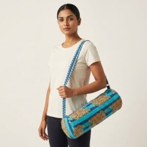 A fitness enthusiast carrying the Blue Tiger Print Yoga Mat Bag over the shoulder by the wide straps, showcasing its long profile and classic bohemian accessory style while heading to a yoga studio class.