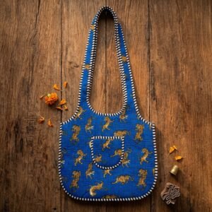 Close-up of the handcrafted blue wild cat print detailing, dense quilted stitching texture lines, robust handle strap attachments, and clean inner layout on an Indian cotton market purse.