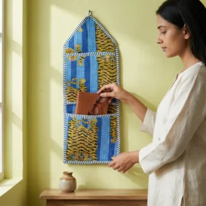 Blue Tiger Quilted Wall Hanging Organizer displaying the multi-pocket vertical sorting slots with the traditional wild cat print artisan design hung securely on an entryway wall.