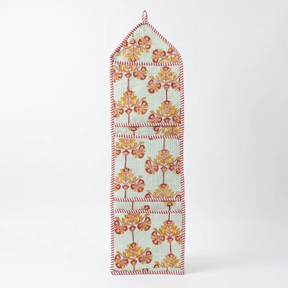Close-up of the handcrafted botanical print detailing, dense quilted stitching texture lines, robust pocket seam attachments, and clean pocket opening on the cotton pocket storage.